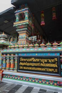 Colorful decorations adorn the large Wat Khaek temple building in Bangkok, featuring a prominent sign in front. Must-Visit Temples in Bangkok.