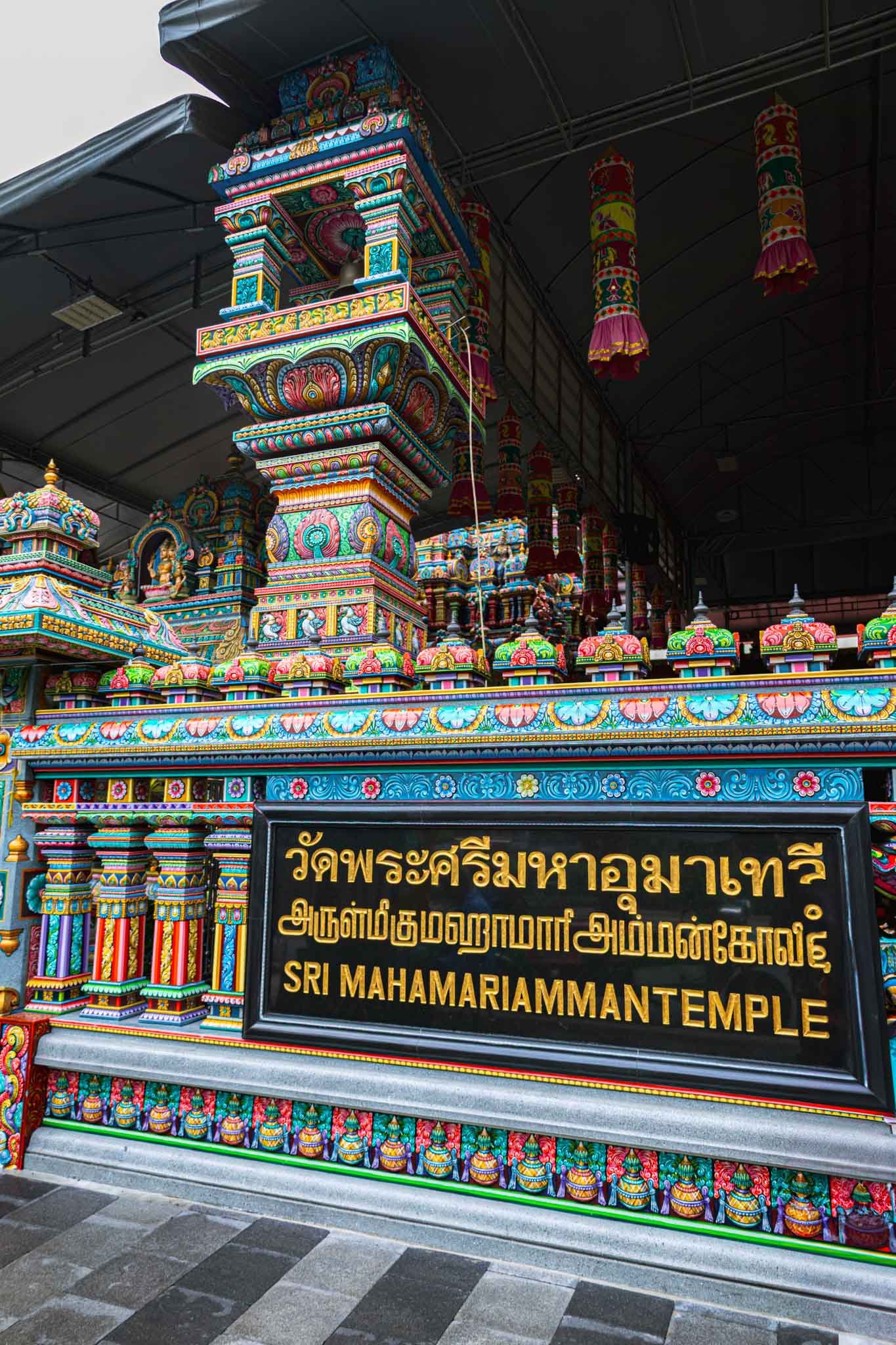 Sign in front of Wat Khaek (Sri Maha Mariamman Temple) in Bangkok, Thailand - Yati Travel Colorful decorations adorn the large Wat Khaek temple building in Bangkok, featuring a prominent sign in front. Must-Visit Temples in Bangkok.