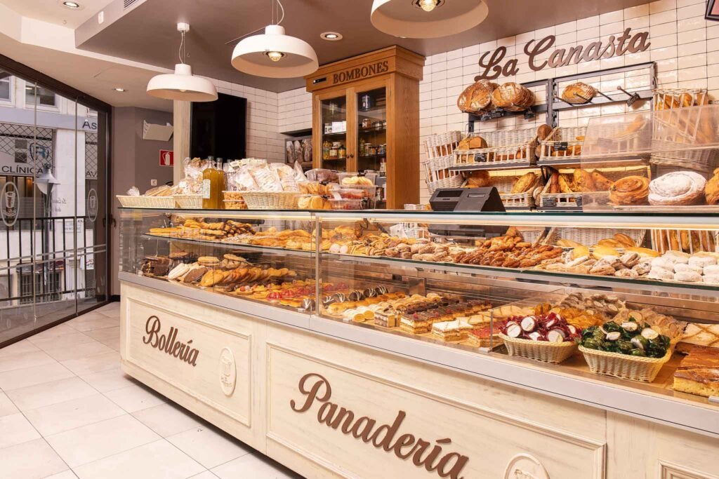 A vibrant display of various breads and pastries at Bakery La Canasta in Málaga, Spain, inviting customers to indulge. Best Places to Eat in Málaga.