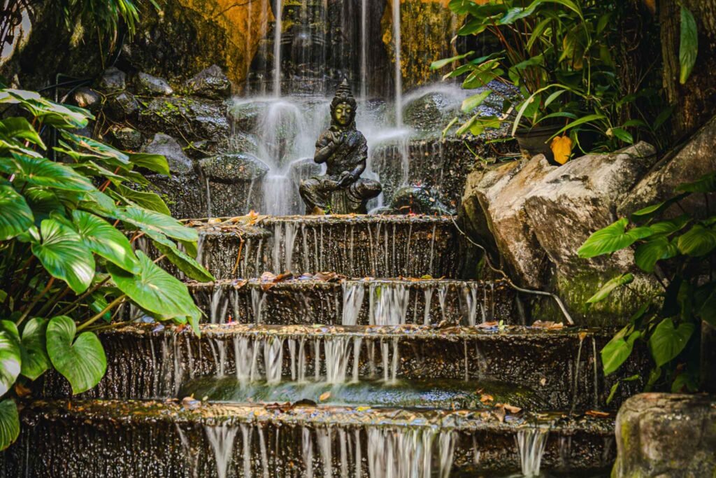 Buddha Waterfall inside The Golden Mount in Bangkok, Thailand V2 - Yati Travel A serene Buddha water fountain waterfall in a garden at The Golden Mount, Bangkok, Thailand. Thailand Travel Guide.