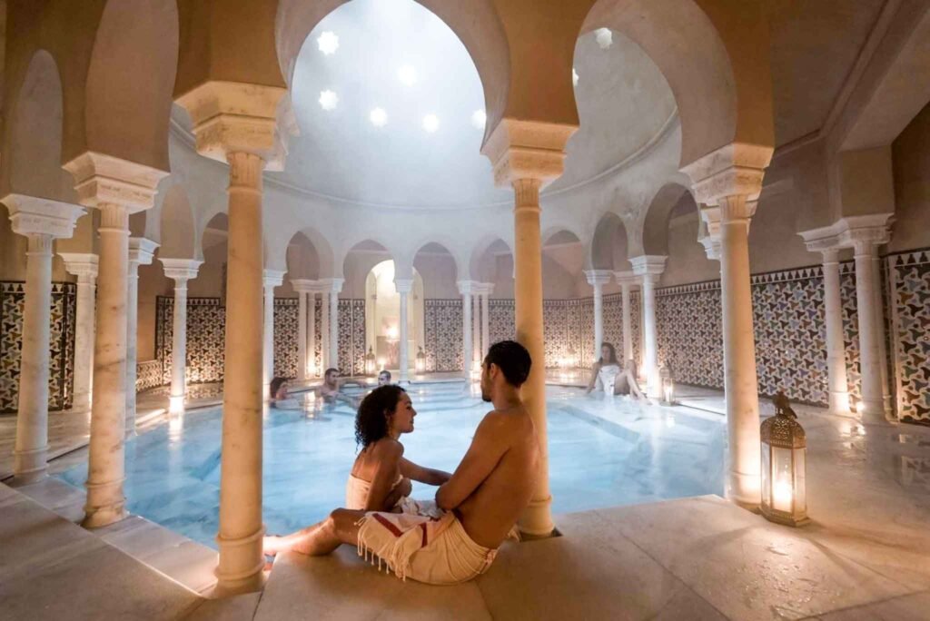 Hammam Al Ándalus Baños Árabes in Málaga, Spain - Yati Travel A couple relaxes together in the indoor pool at Hammam Al Ándalus Baños Árabes spa in Málaga, Spain. Best Things to Do in Málaga.