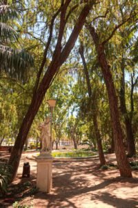 A statue in Parque de Málaga, surrounded by greenery and park scenery. Best Things to Do in Málaga.