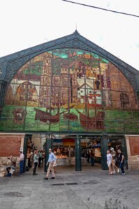 The exterior of Mercado de Atarazanas in Málaga, Spain, showcasing a large building adorned with a colorful mural. Best Things to Do in Málaga.