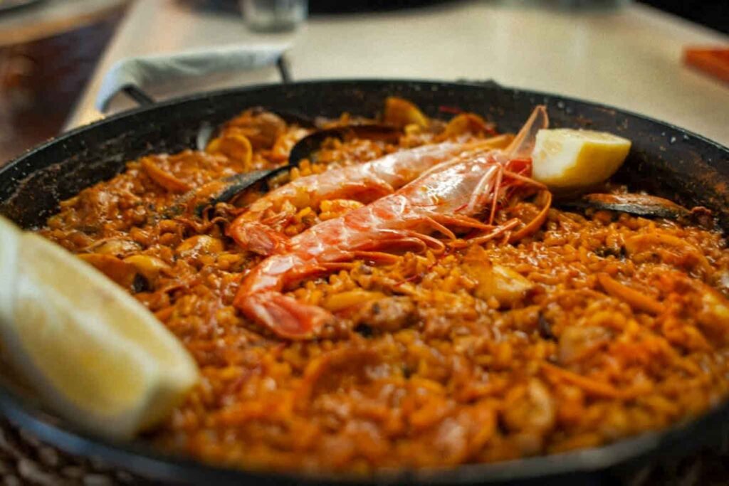 A vibrant pan of paella filled with seafood and rice, served at Los Marangós Molina Lario in Málaga, Spain. Best Places to Eat in Málaga.
