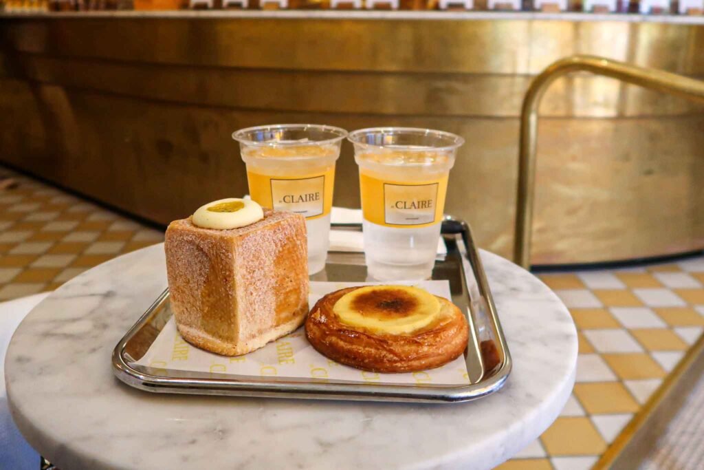 A tray featuring a pastry and two glasses, served at Et Claire in Amsterdam, inviting for a delightful treat. Best Bakeries in Amsterdam.