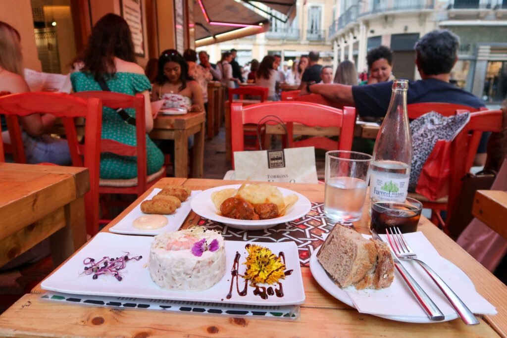 A table set with various dishes and drinks at Restaurant LOLITA Taberna Andaluza in Málaga, Spain. Best Places to Eat in Málaga.
