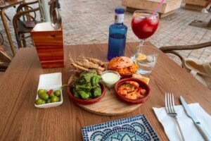 A table set with various tapas and drinks at Picasso Bar Tapas in Málaga, Spain, inviting a delightful dining experience. Best Things to Do in Málaga. Best Places to Eat in Málaga.