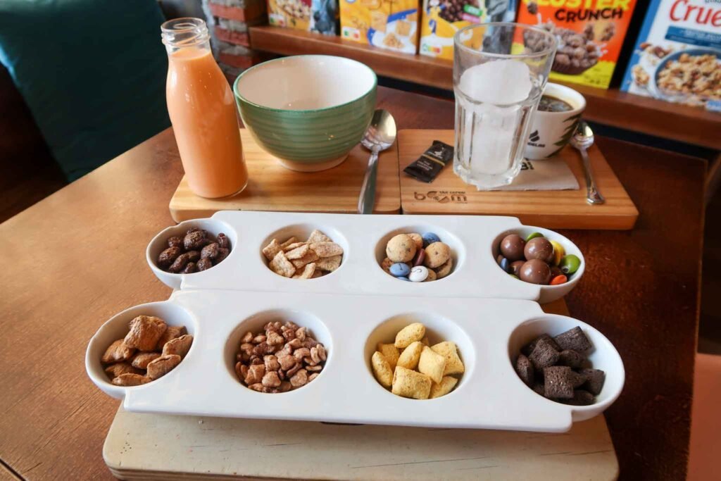A tray of colorful cereal and mixed nuts on a table at Cereal Boom Coffee in Málaga, Spain. Best Places to Eat in Málaga.
