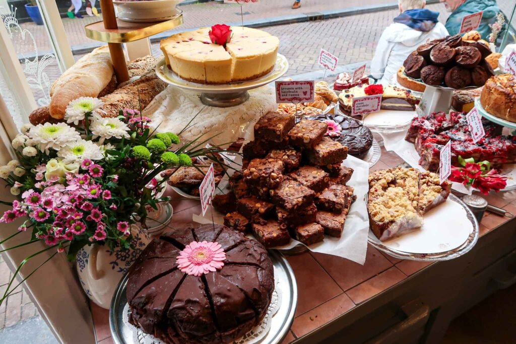A table filled with a variety of cakes, brownies, and cookies at De Laatste Kruimel in Amsterdam. Best Bakeries in Amsterdam.